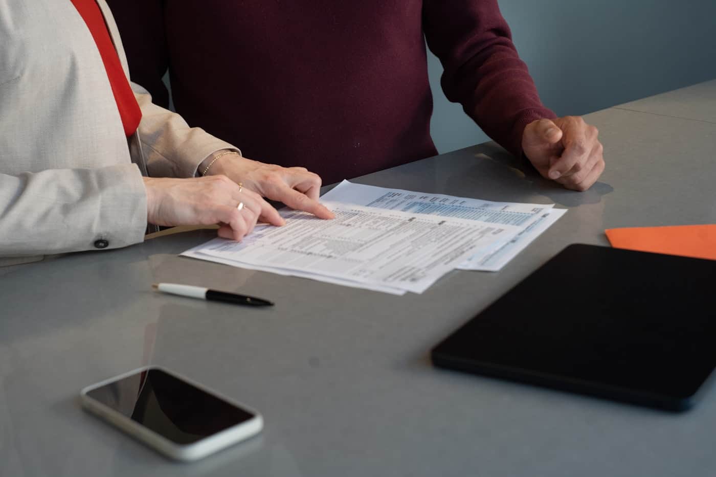 Two generations of a family working through business papers together at a table