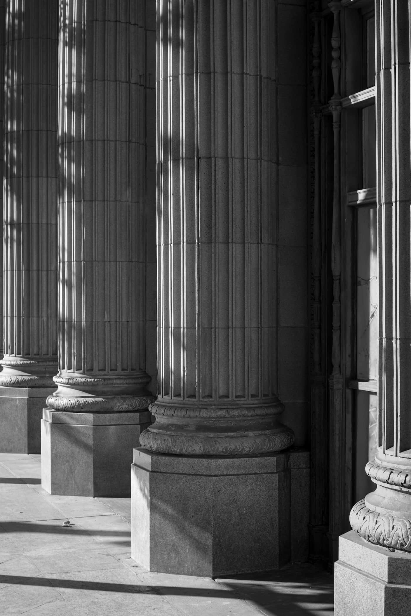Fluted stone columns at a courthouse entrance, photographed in raking light