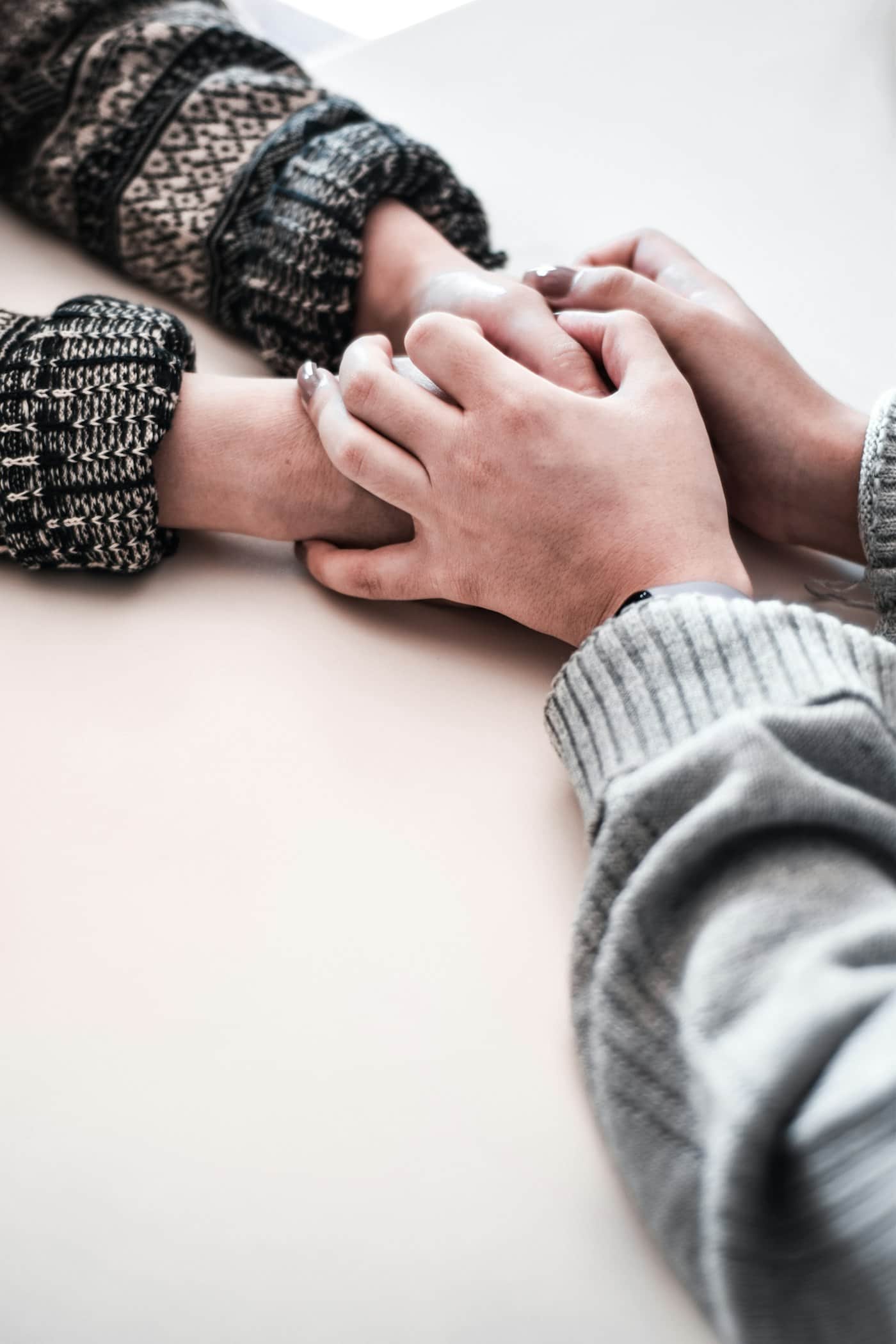 Two generations' hands clasped together across a table